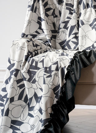 a black and white blanket sitting on top of a couch