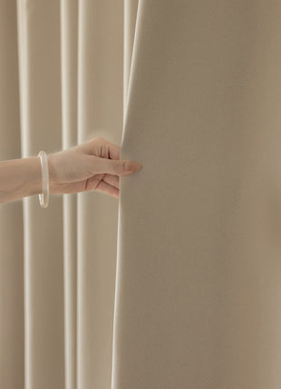 a person holding onto a curtain with their hand