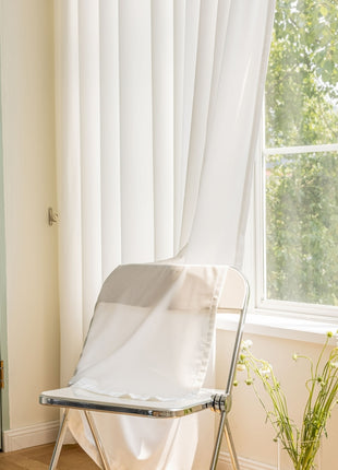 a white folding chair sitting in front of a window
