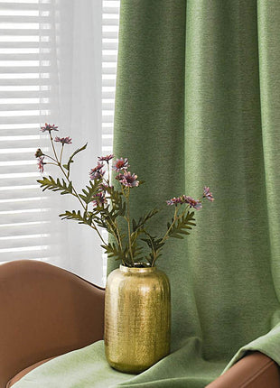 a vase of flowers sitting on a chair in front of a window