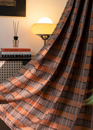 a room with a bed, a lamp, a clock and a curtain