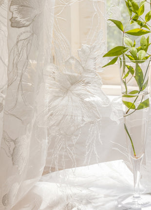 a vase with a plant in it next to a window