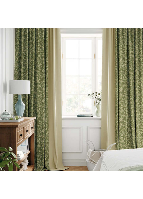 a bedroom with green curtains and a white bed