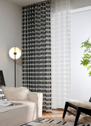 a living room with a white couch and a black and white rug