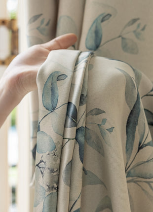a person holding a curtain with a flower pattern on it