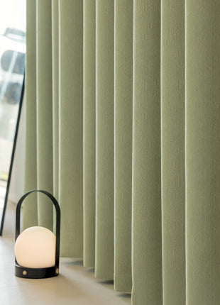 a lamp sitting on the floor next to a window