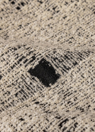 a close up of a sweater with a black hole in the middle