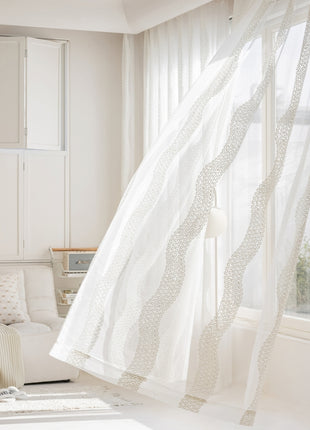 a living room with a white couch and curtains