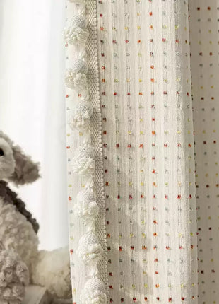 a stuffed dog sitting next to a curtain