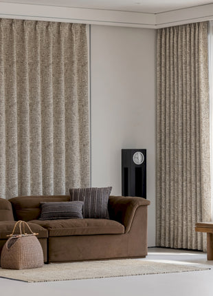 a living room with a brown couch and a clock