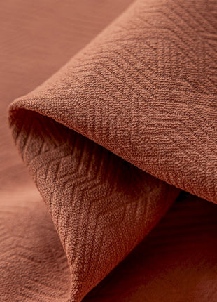 a close up view of a bed with a pink comforter