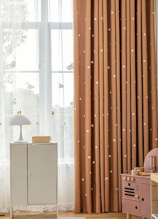 a child's room with a dresser and curtains