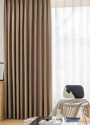 a living room filled with furniture and a window covered in curtains