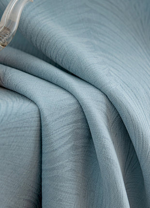 a bed with a blue bedspread and a teapot on top of it