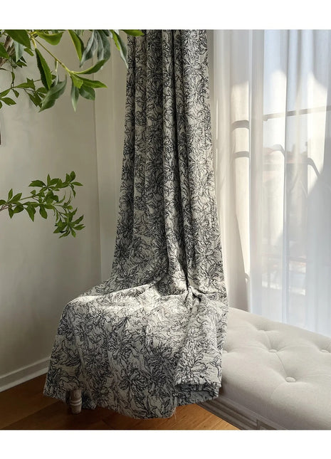 a white couch sitting under a window next to a plant