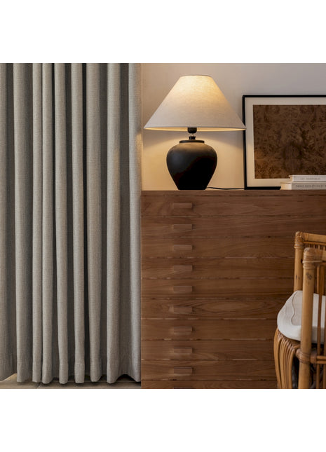 a living room with a lamp a chair and a window