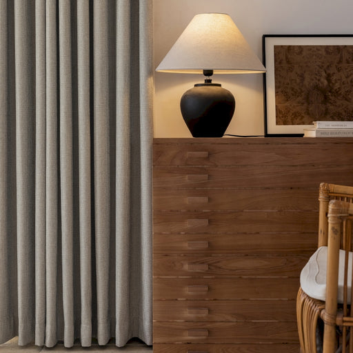 a living room with a lamp a chair and a window