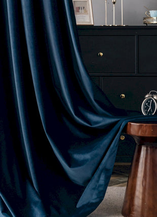 a room with a black dresser and a blue curtain