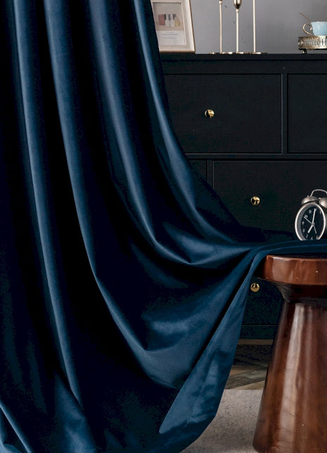 a room with a black dresser and a blue curtain