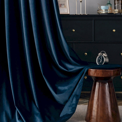a room with a black dresser and a blue curtain