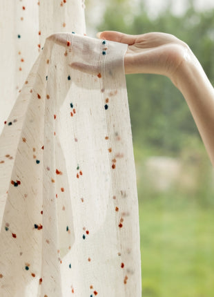 a person is holding a curtain with a hand