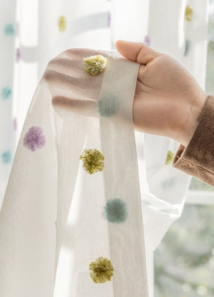 a person holding a curtain with a flower on it
