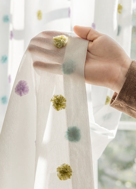 a person holding a curtain with a flower on it