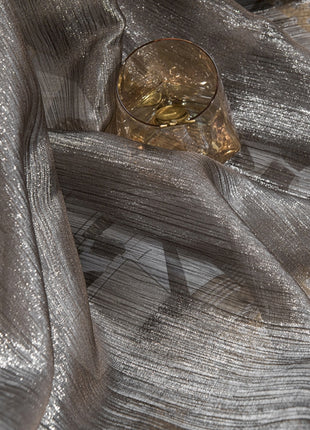 a glass sitting on top of a silver cloth