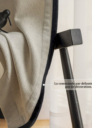 a black bird sitting on top of a chair next to a window