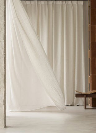 a room with a white curtain and a chair