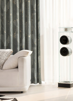 a living room with a white couch and speakers