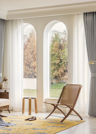 a living room filled with furniture and large windows