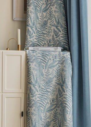 a blue and white curtain hanging from a window