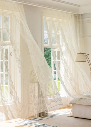a living room with white curtains and a couch