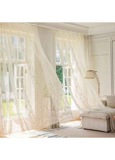 a living room with white curtains and a couch