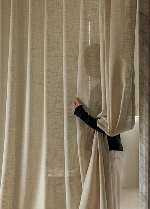 a person standing behind a curtain in a room