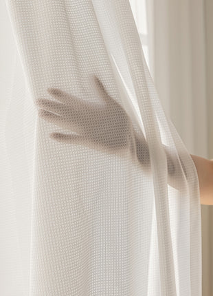 a woman is pulling up a white curtain