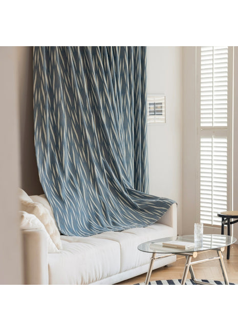 a living room with a white couch and a blue curtain