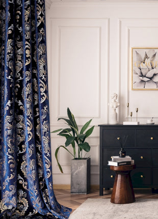a living room with a black dresser and a blue curtain