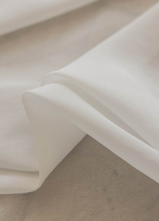 a close up of a white sheet on a bed