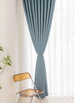 a chair sitting in front of a window next to a potted plant