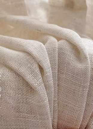 a close up of a chair with a white curtain