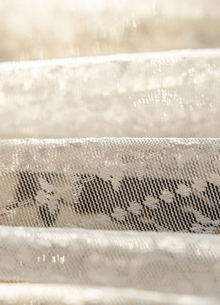 a close up of a baby crib with white sheets