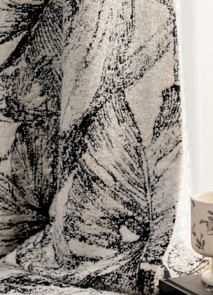 a coffee cup sitting on top of a table next to a curtain