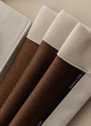 a close-up view of a set of brown and white fabric, possibly curtains or blinds, with a white object in the background.