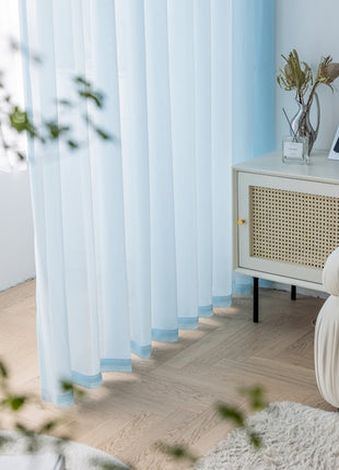 a living room with a white couch and blue curtains