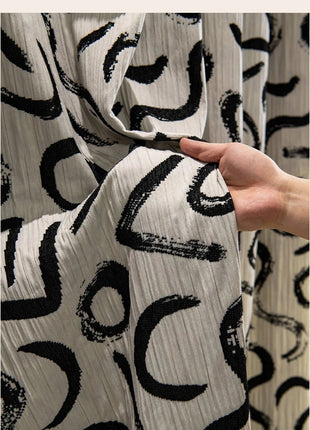 a hand holding a piece of fabric in front of a curtain