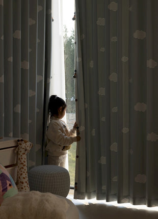 a little girl standing in front of a window