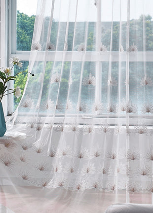 a window with a sheer curtain and a vase with flowers