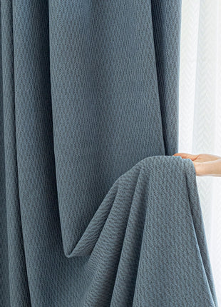 a person is opening a curtain with their hand